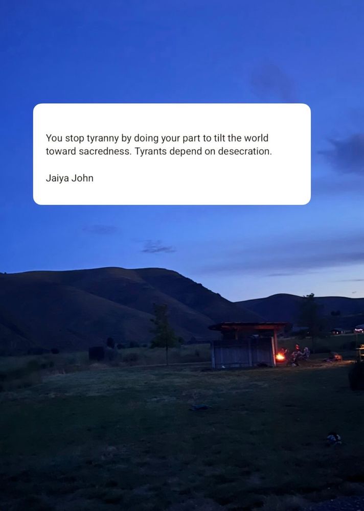 A photo I took of the foothills along the John Day River at dusk with the glow of a campfire in the foreground.  Nested in the photo as a quote by Jaiya John: “You stop tyranny by doing your part to tilt the world toward sacredness. Tyrants depend on desecration.” 
