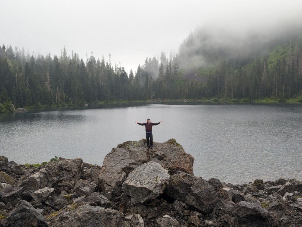 An alpine lake, boulders, and a man