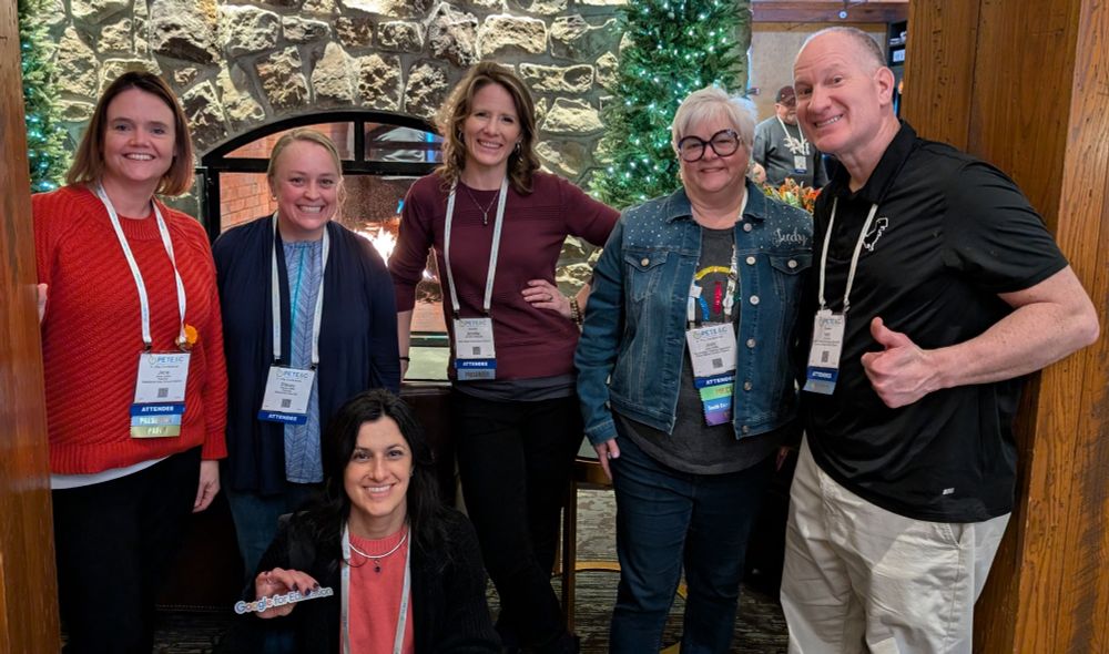 Group shot of six people in front of the Hershey Lodge fireplace.