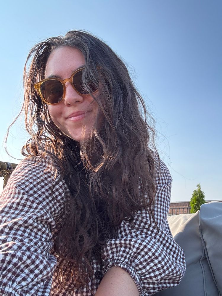 author of the tweet (woman with brown wavy hair wearing sunglasses)