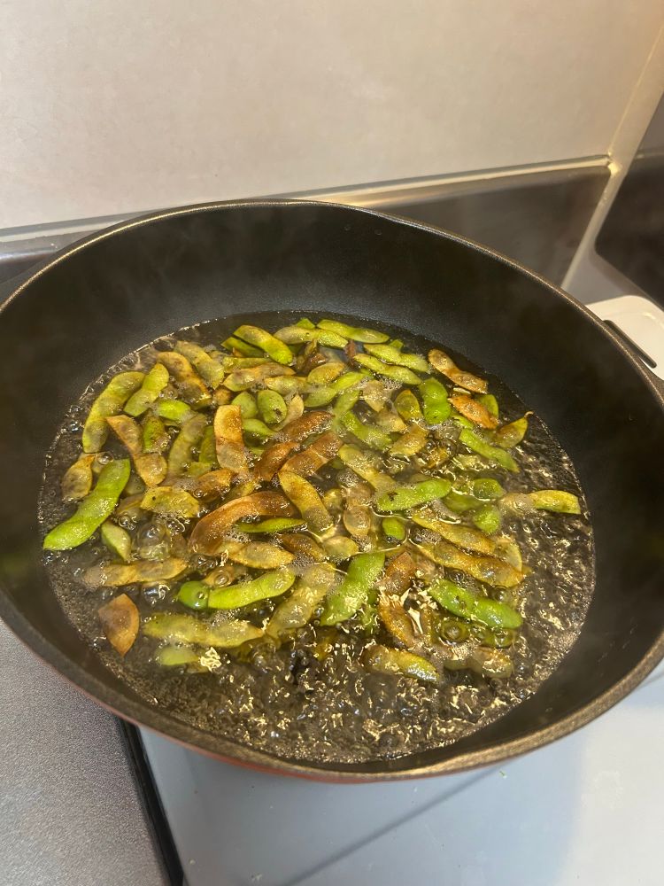 A pot full of boiling water and edamame 