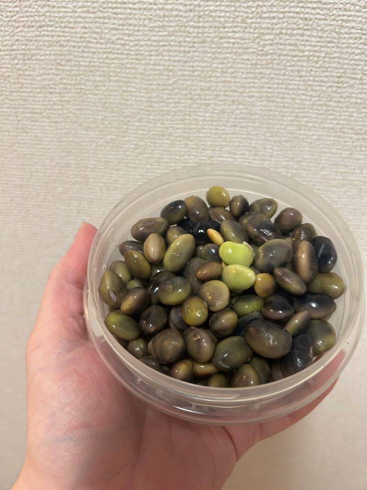 A container of cooked edamame minus their pods 