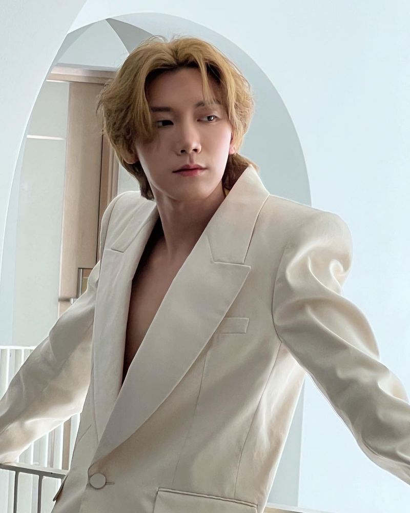 WayV Ten with blonde hair. He’s wearing a white suit jacket buttoned to the middle with his chest and neck exposed. 