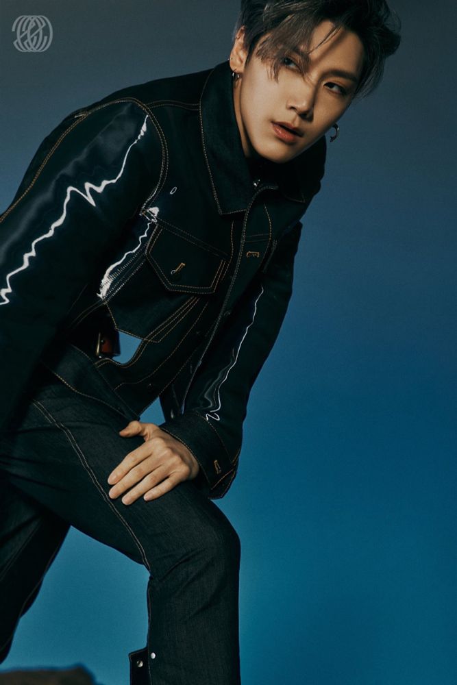 WayV Ten for NCT 2020 photo teasers. He’s wearing a dark blue jean jacket and jeans and he’s leaning forward holding his right knee with his left hand