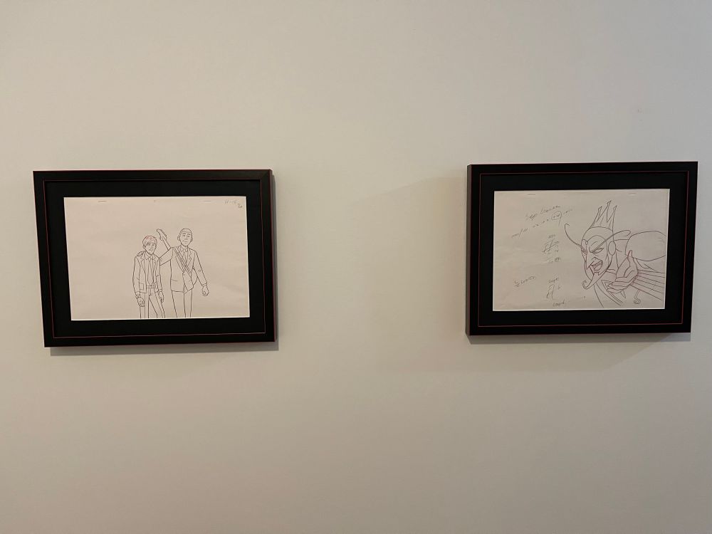 The two framed drawings side by side hung on a wall