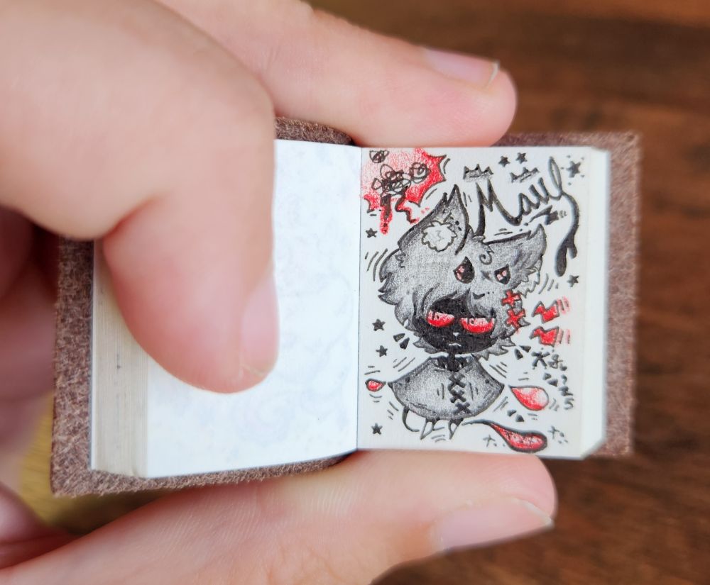 An artfight revenge featuring Maul, a monochrome, black and red kitty with a poncho and demon horns! Has a blood droplet tail and a few blood droplets at the edges of his poncho. "Maul" is written in cursive text above! Character does not belong to me!