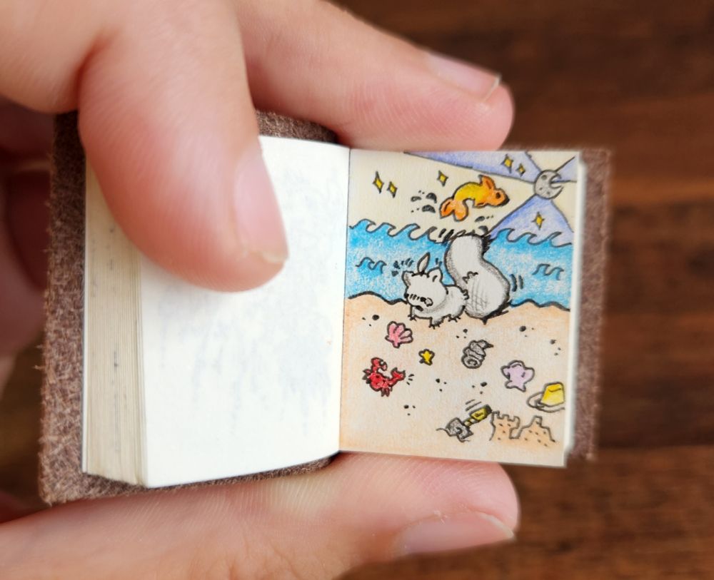 An artfight attack on Xu_11 from toyhou.se of their OC Soli! In a mini sketchbook with a small moonlit beach harboring seashells scattered across the sand. Along with one red crab, a bucket, small shovel, and sand castle. ✨️🏝