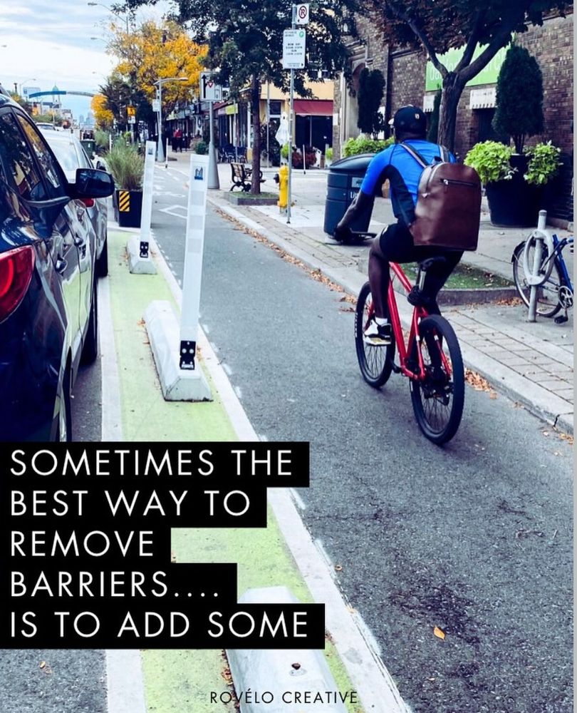 Person biking in a protected bike lane.
Sometimes the best way to remove barriers is to add some. 