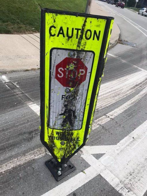 a mangled Caution Flexpost with tire tracks behind it in a bike lane