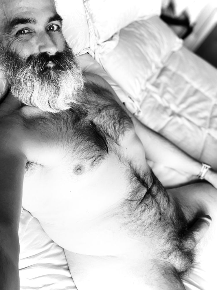 David looks at the camera with a mischievous grin. He is naked and his cock is flopping languidly on his thigh. The image is black and white, because it’s Monday. 