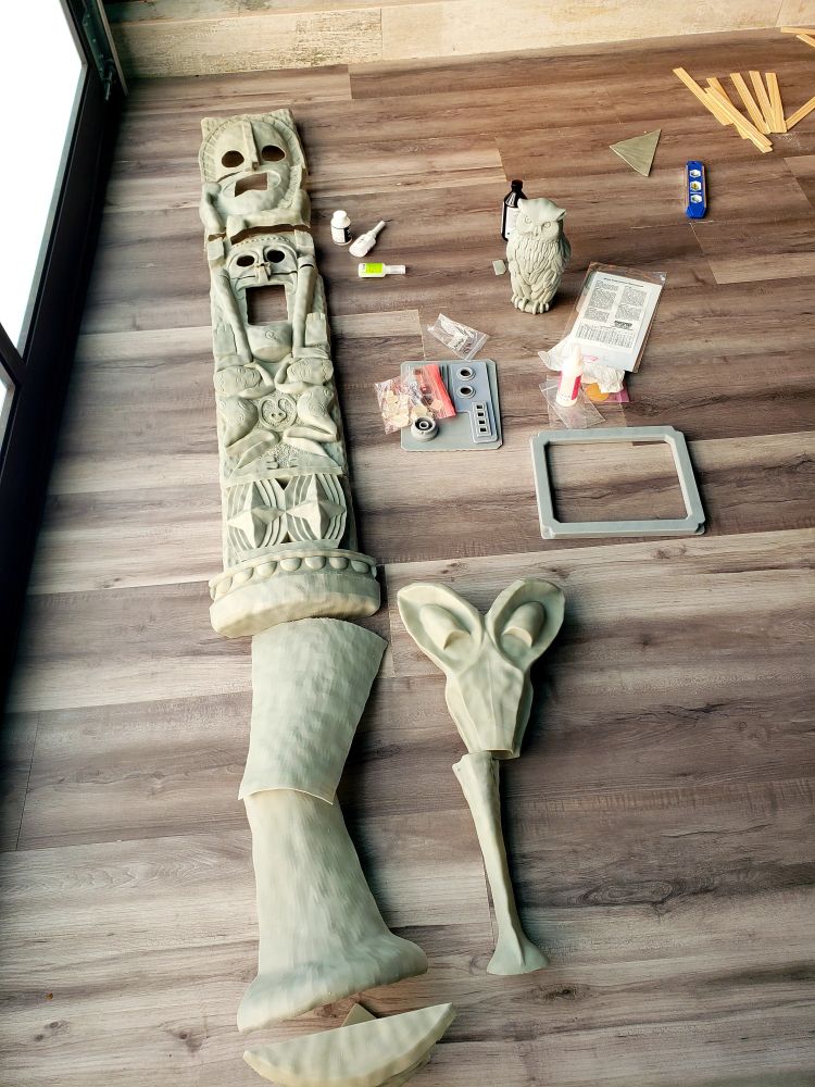 An unpainted 3D print of a pole from the Enchanted Tiki Room at Disneyland lying on the ground