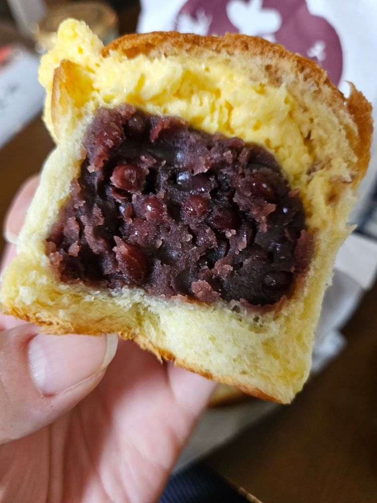 あんぱんを割ったところを撮った写真。あんこがぎっしり入っていて、上にバターが入っている。