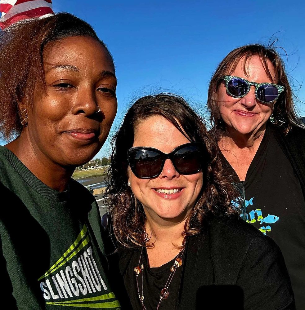 Slingshot's Bennett Dawson, Undersecretary Maria Belen Power, and CLean WAter's Cindy Luppi smile for a selfie