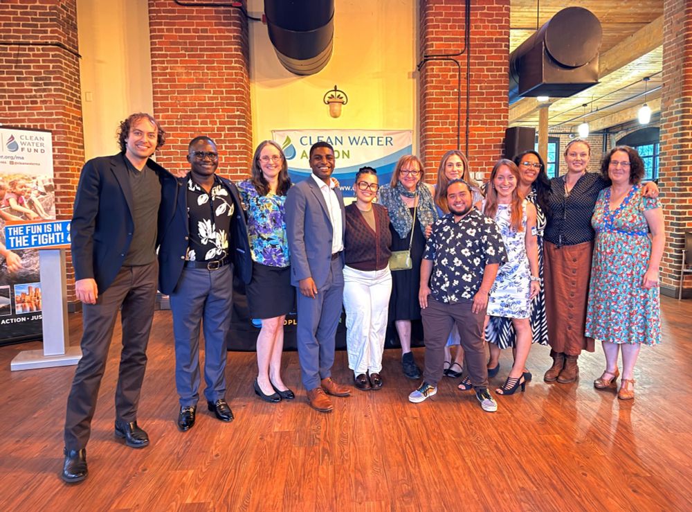 the clean water team, past and present, pose in activist chic attire for a group photo at their event