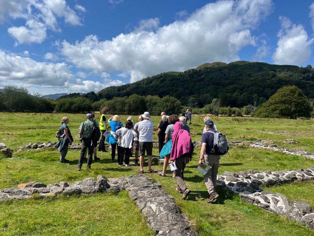 A group listens to a trail tour by Rowan Colley in Ambleside Roman Fort
