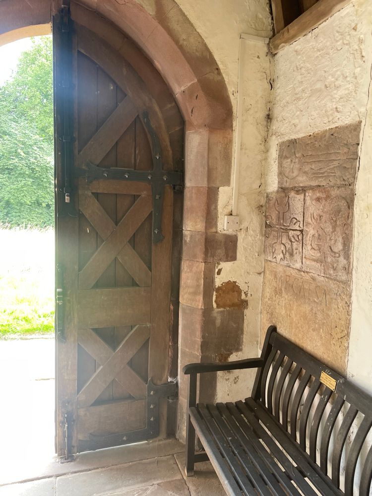Picture of a church entranceway with a Roman inscription built into the wall 
