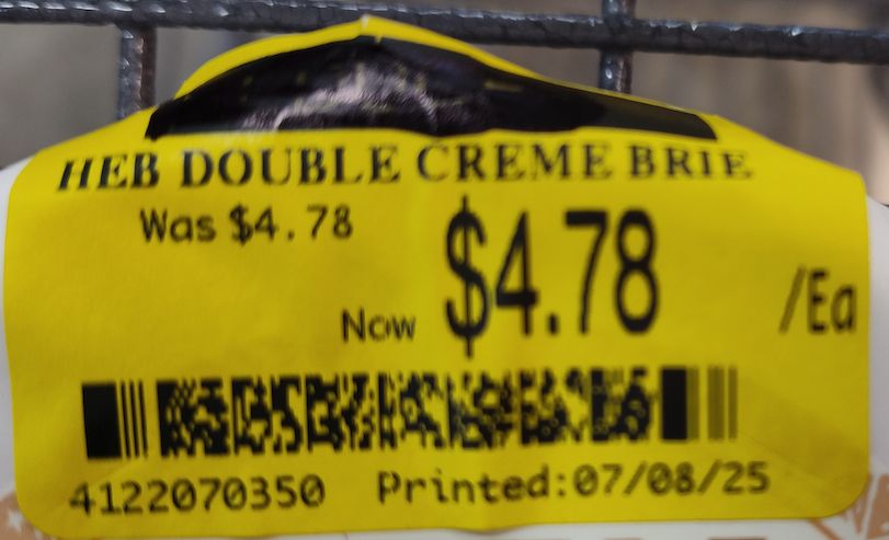 Label on a wheel of cheese displaying a markdown from $4.78 to $4.78.