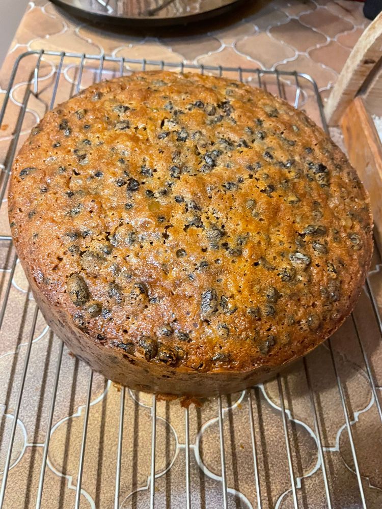 Photograph of a fruit cake on a cooling rack