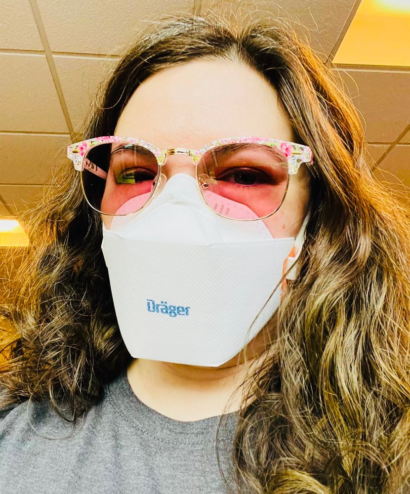 I'm wearing pink lens glasses with gold and floral frames, a gray shirt, and a white drager n95 mask.