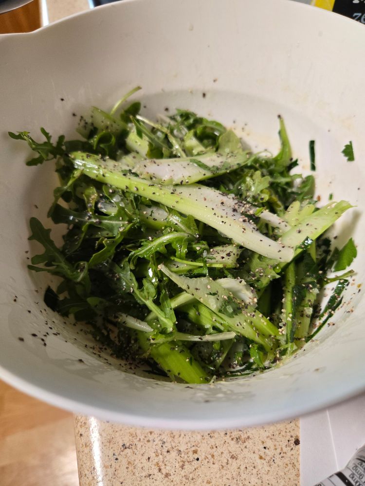 A salad with celery, flat parsley, arugula, coarse salt, pepper, and a lemon vinaigrette 