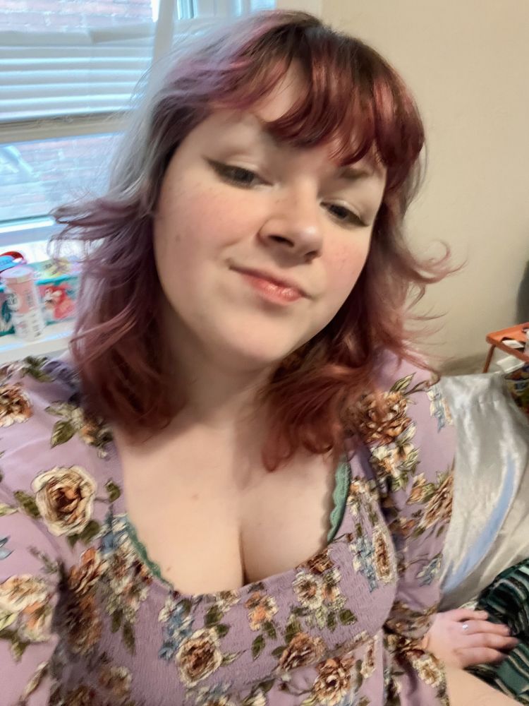skyler in a purple floral dress. her hair has big wavy curls in it!
