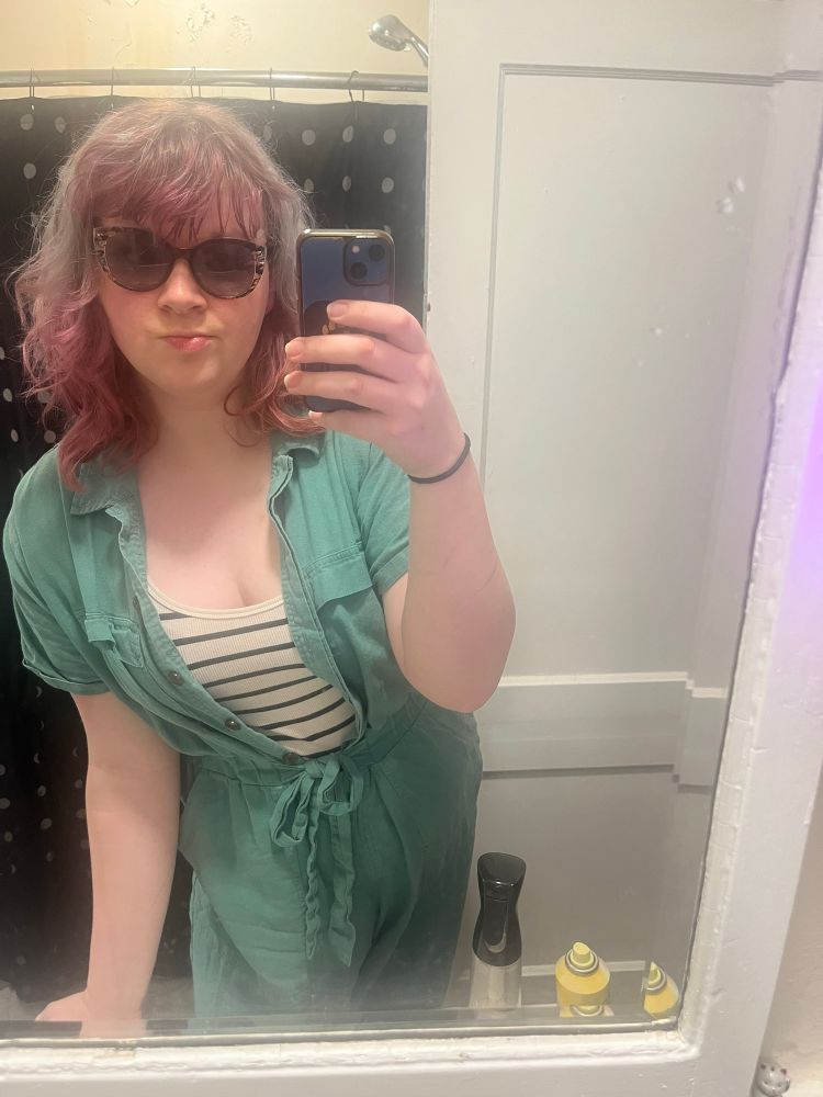 skyler bathroom selfie! shes wearing a teal romper and a striped tank top and sunglasses