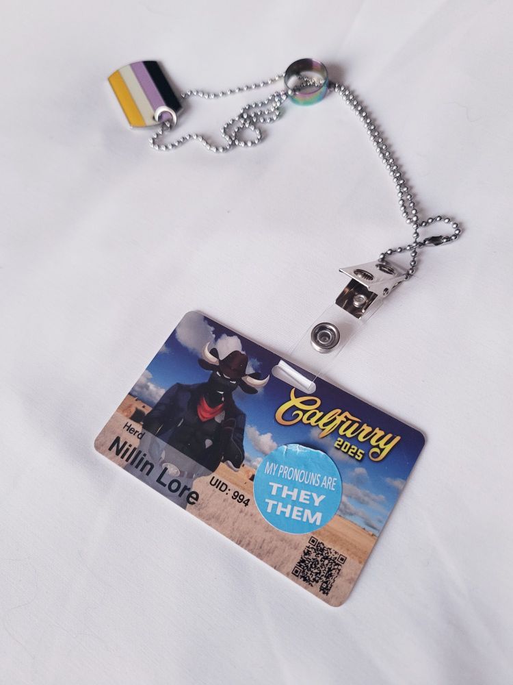 Con badge for Calfurry showing my name and a pronouns sticker.