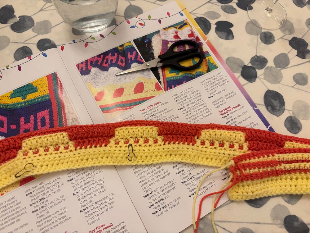 A strip of red and yellow mosaic crochet, with the instructions behind. 