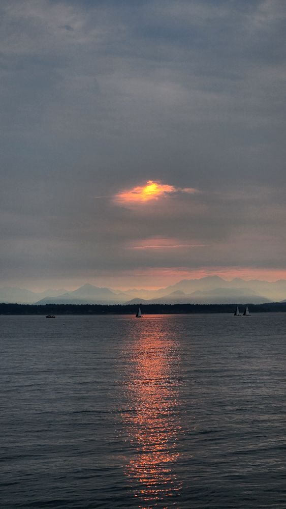 Smoky red sunset over the Olympic Mountains seen from Golden Gardens in Seattle, August 27th, 2025