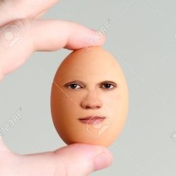 Some one holding an egg with a face on it