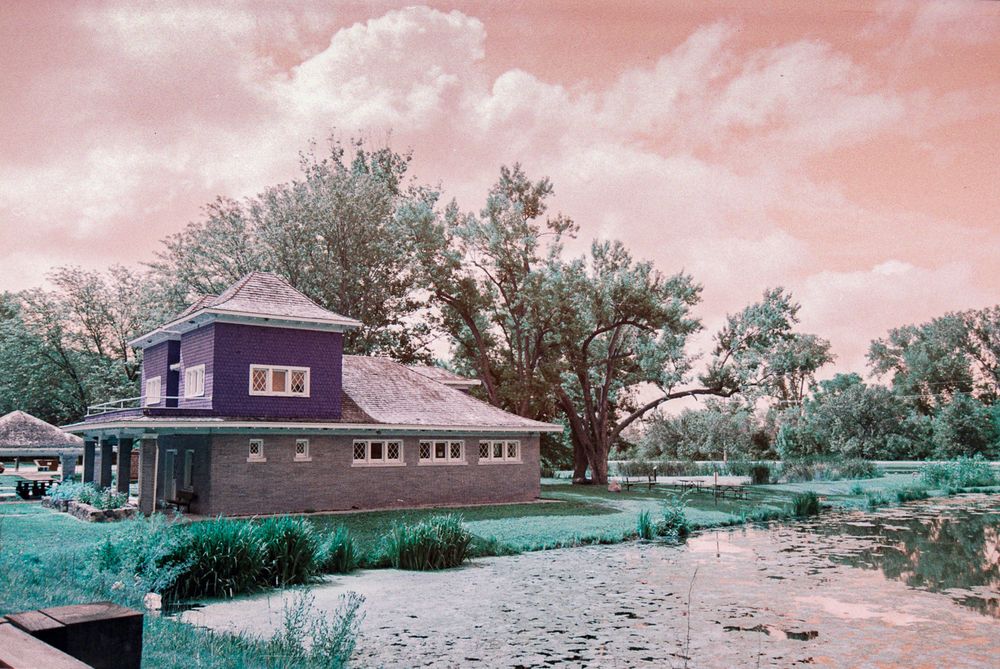 The old fish hatchery appearing in burgundy tones against a dramatic peach sky.