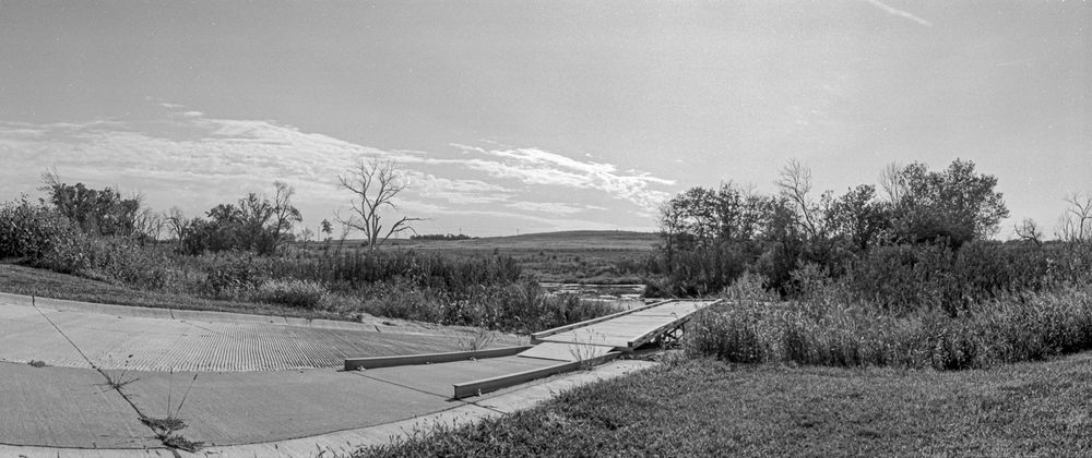 Panoramic view of a lakeside dock shot on a camera with a rotating turret, which results in an almost fisheye result.