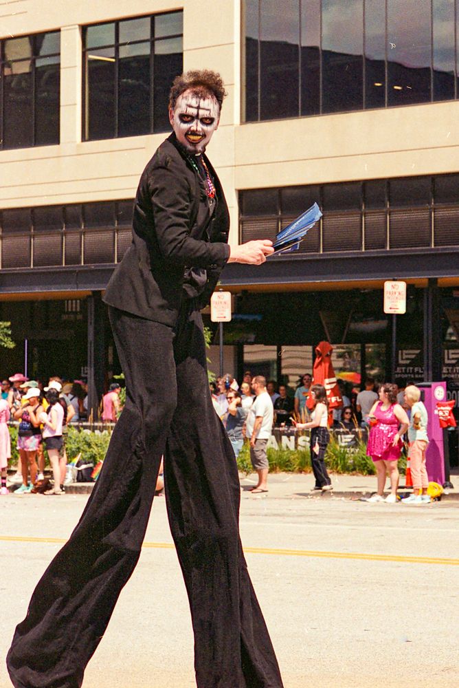 A beetlejuice-type character on stilts at Pride Parade. Zoom in on his eyes.