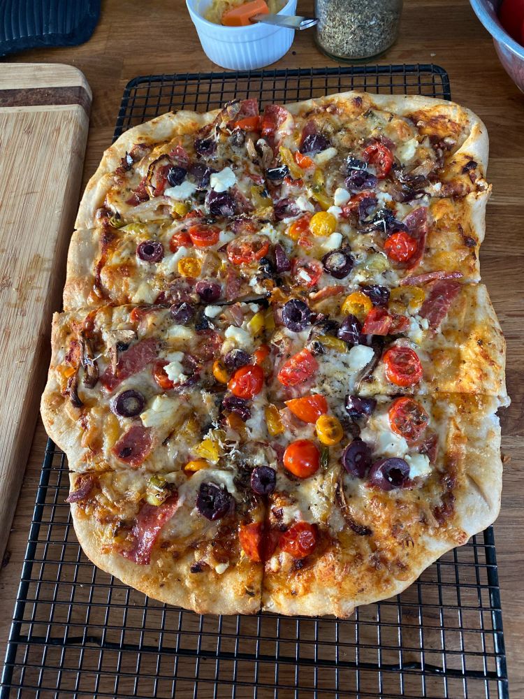 Cooked and sliced homemade pizza on a cooling rack.