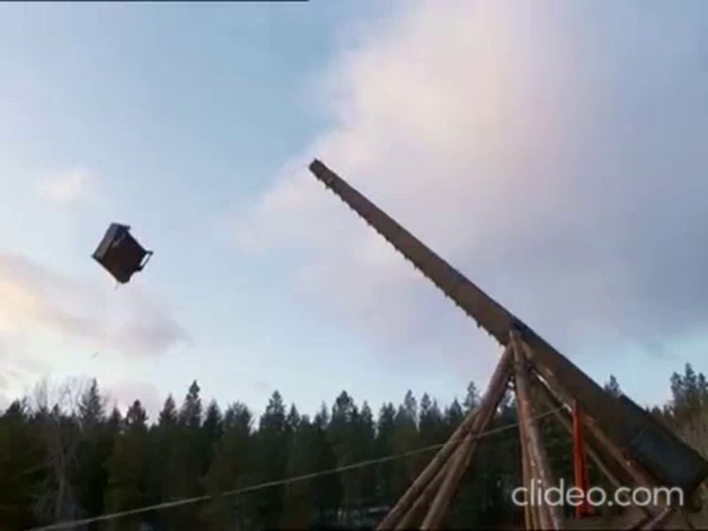 a box is being thrown into the air by a giant saw .