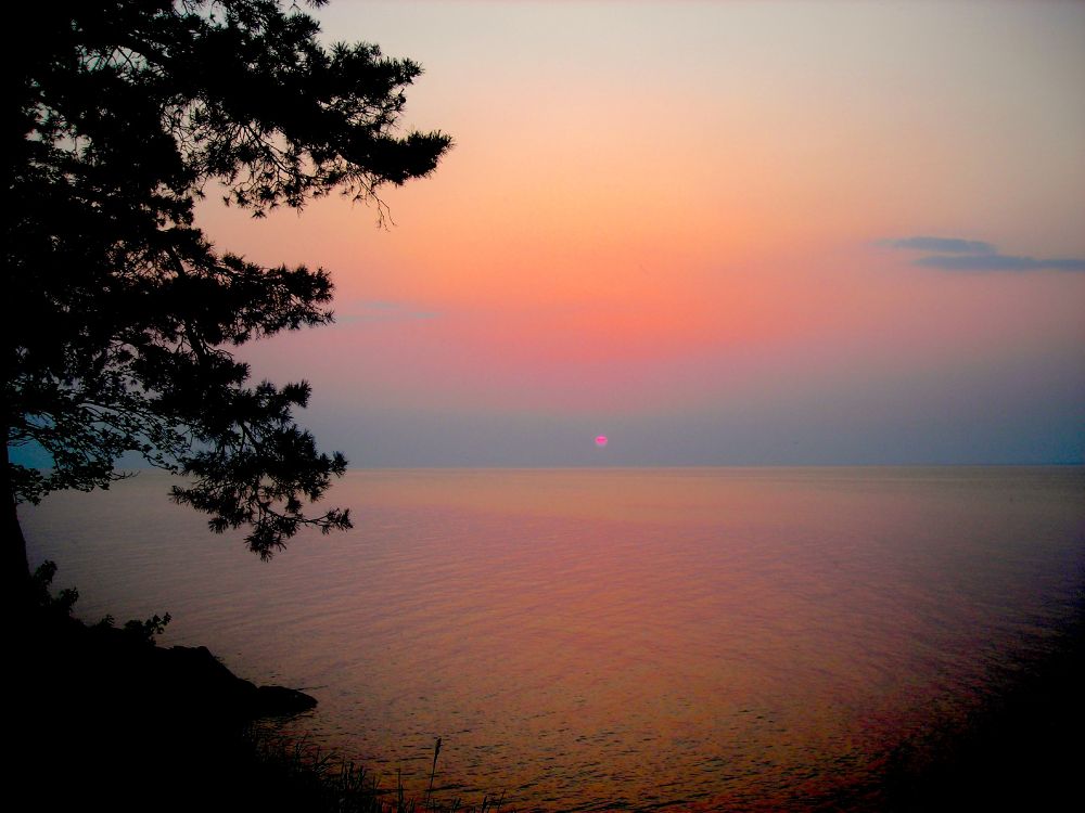 A color photo of a hazy sunset above Lake Erie.