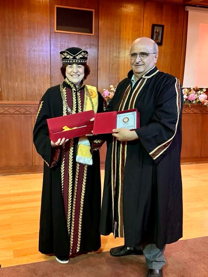 Distinguished Professor Sharynne McLeod dressed in a toga and medals with the Rector of the University of Patras