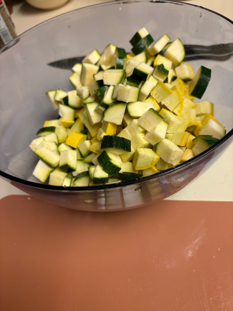 A bowl of chunks of zucchini and yellow squash, each piece about pinky end-joint size (perfect for spooning)