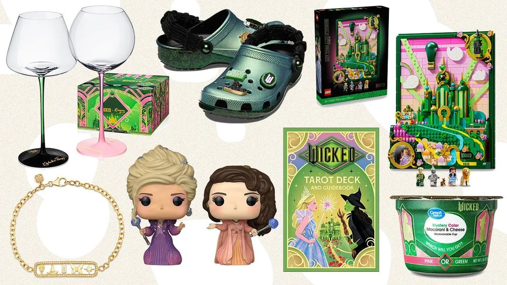 An image of new Wicked tie-in crap includes pink- and green-stemmed wineglasses; hideous green Crocs; some Lego bits; a tarot deck, Funko pops, a gold necklace, and a microwavable cup of macaroni and cheese that comes in MYSTERY COLOR: will you get pink or green?