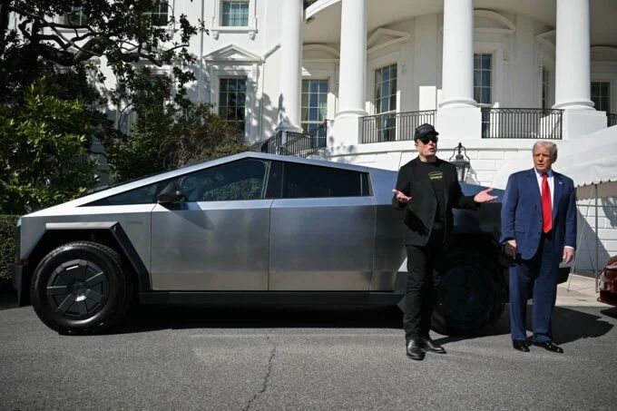 Elon Musk and Donald Trump standing by a Cybertruck in front of the White House.