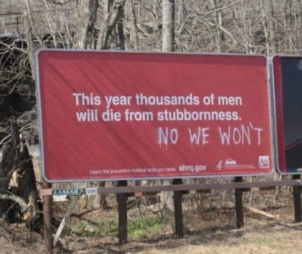 Advertising hoarding – this year thousands of men will die from stubbornness.
Graffiti below "no we won't"