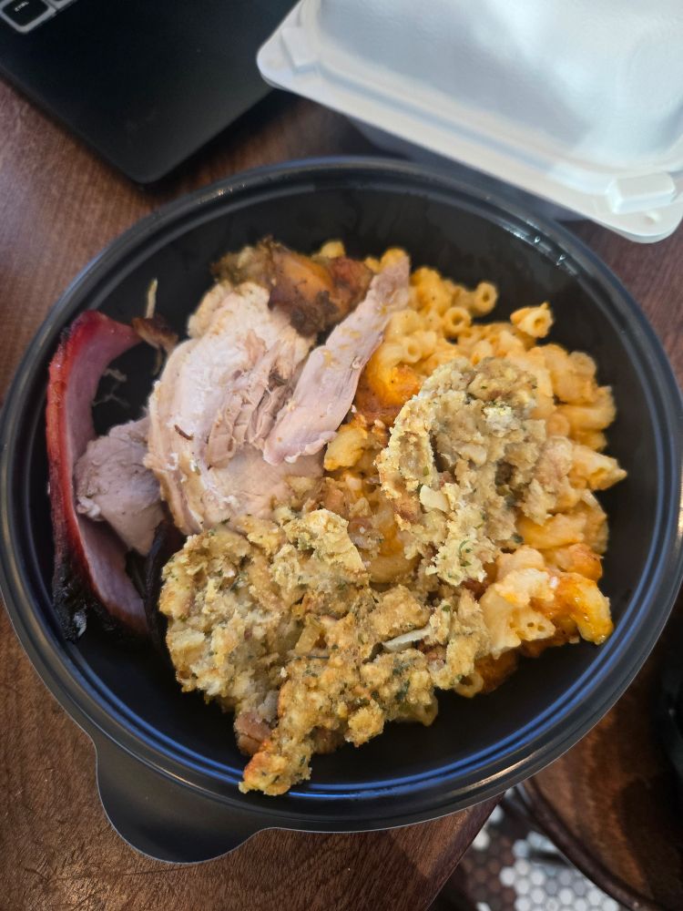 A Thanksgiving plate with stuffing, mac n cheese, turkey and ham