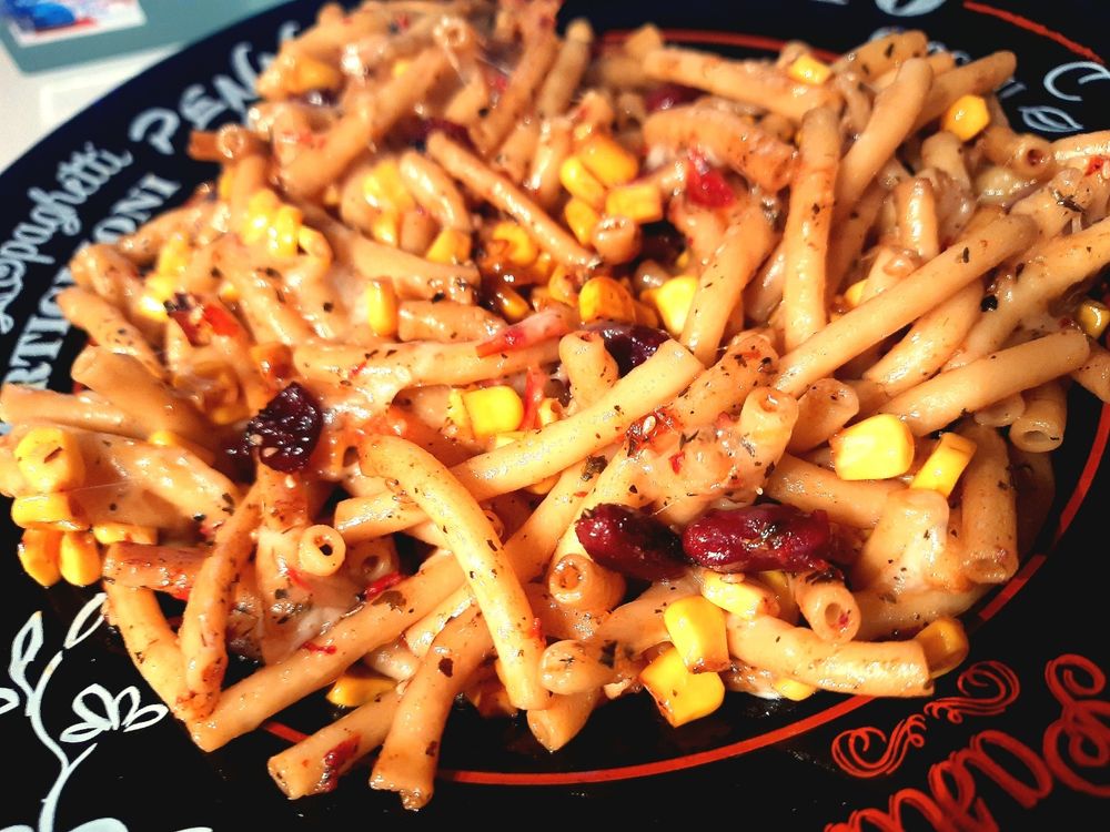 Das beschriebene Gericht auf einem schwarzen Tellee mit weißen und roten Verzierungen.