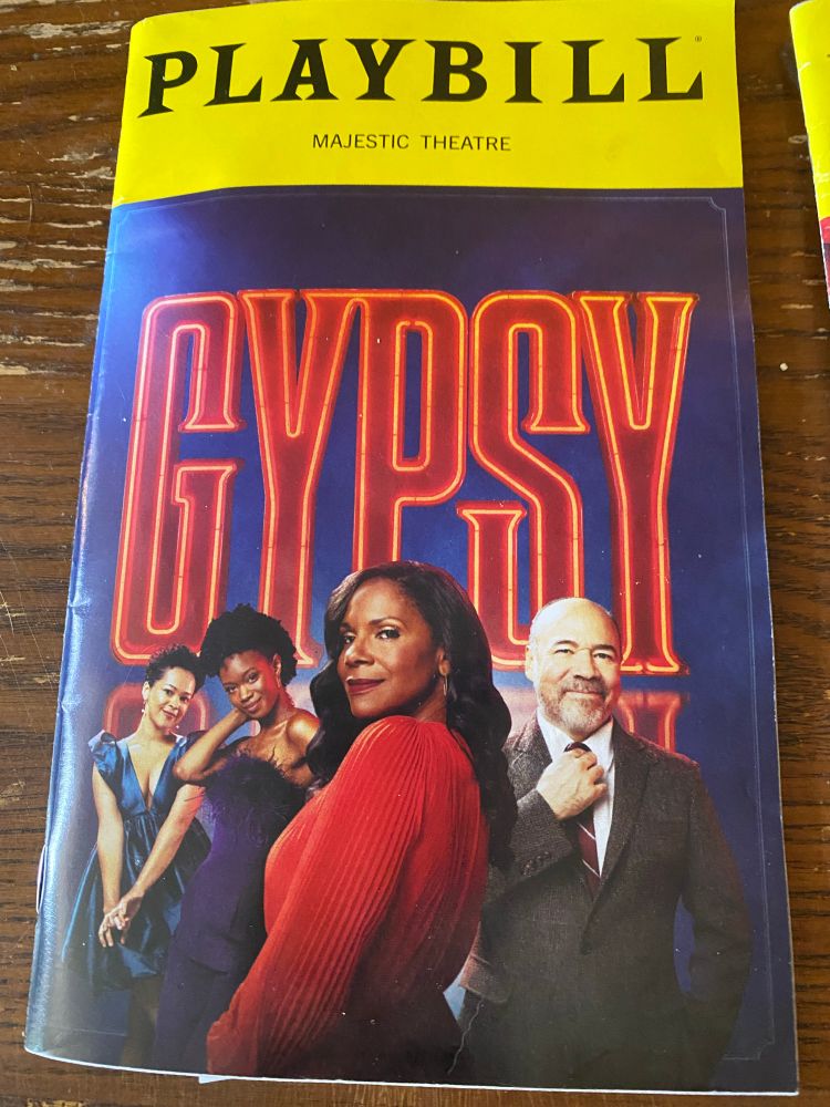 Playbill program for Gypsy. Pictures is a black woman in a red dress looking over her shoulder, a gentleman in a suit and two young ladies in blue dresses.