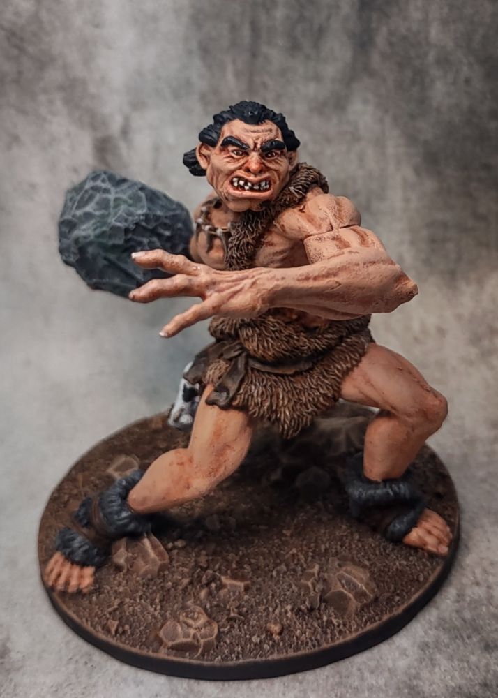 Front facing view of a painted hill giant miniature by Gale Force 9, outstretched and tossing a boulder. 