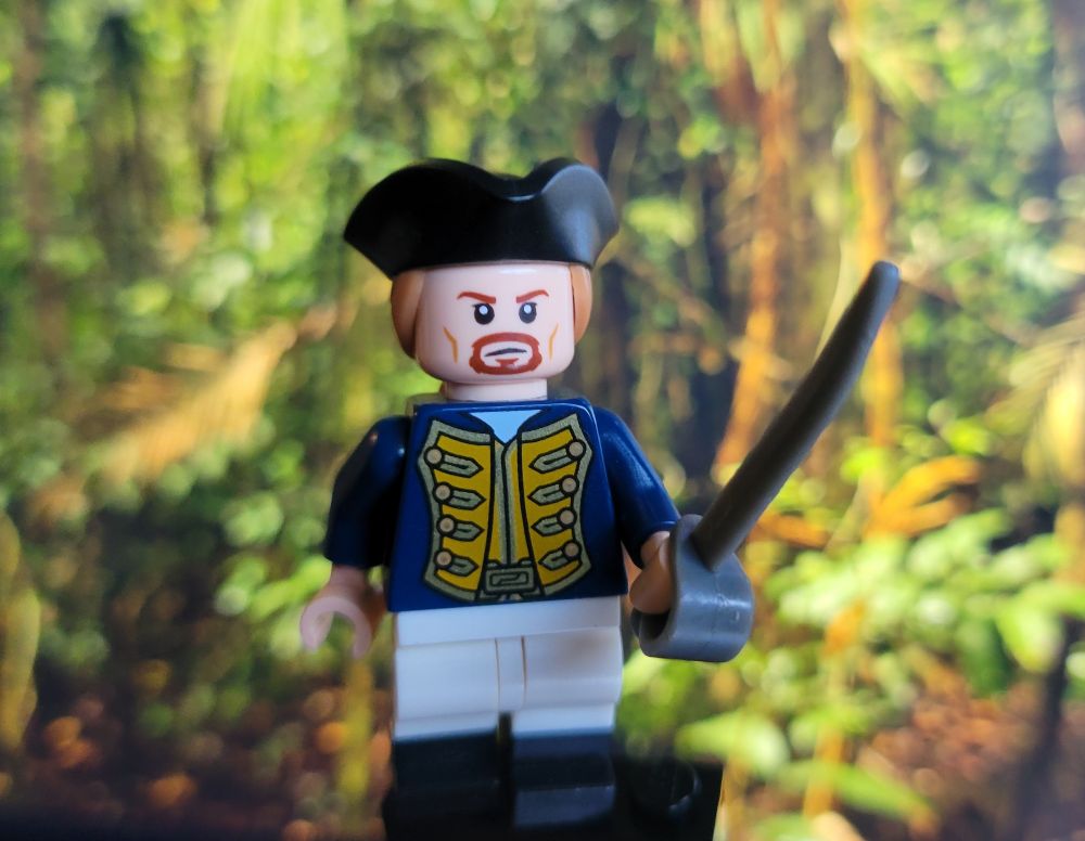 Lego Alex Sherman posing with his cutlass in front of a lush jungle backdrop. He's dressed as a British Navy officer and is ready to take on any dastardly pirates that cross his path