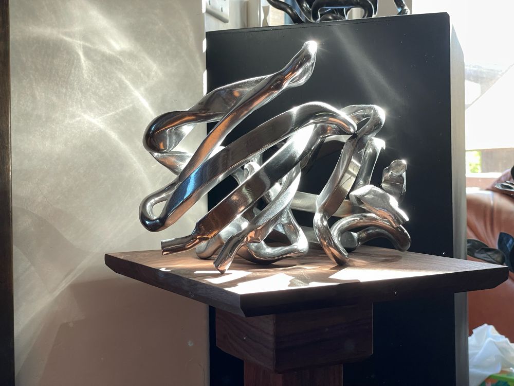 Light reflecting off a sculpture of different structural domains found in proteins. Made from steel. 