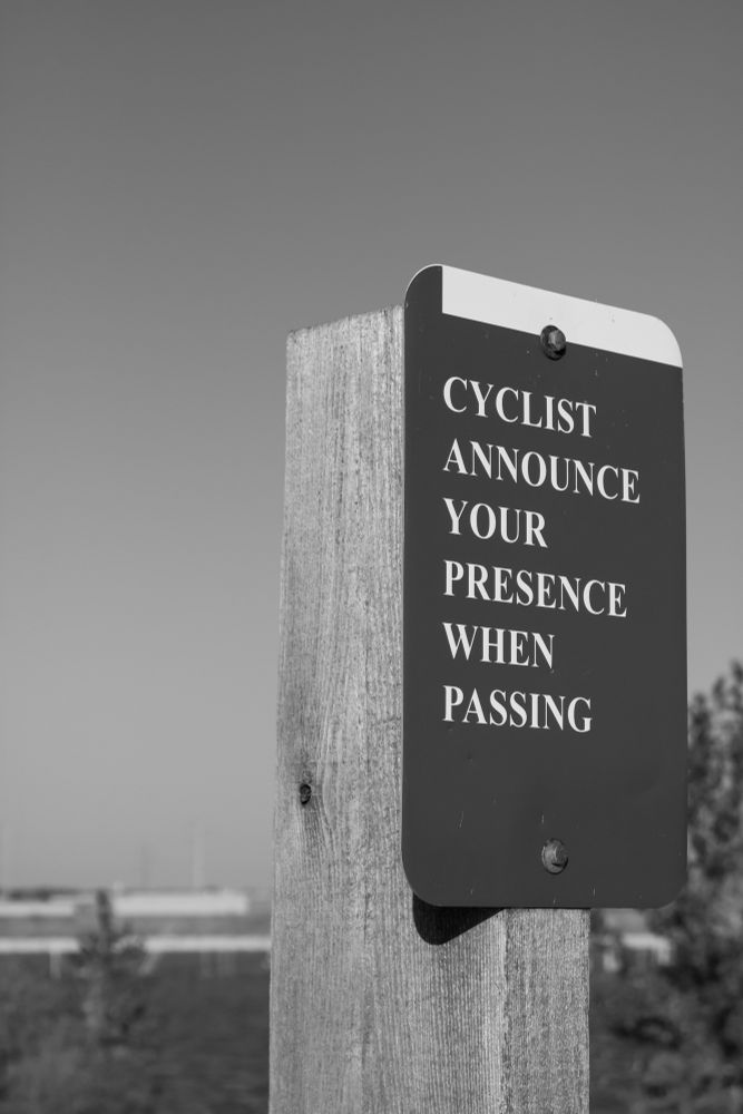 A black and white photo of a cyclist sign for announcing your presence when passing.