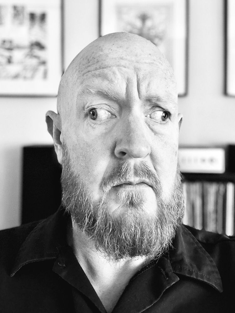 Black and white photo of a man with eyes pointing in different directions.