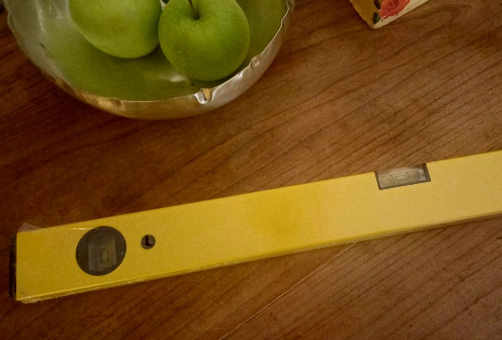 Yellow spirit level on a wooden table. 